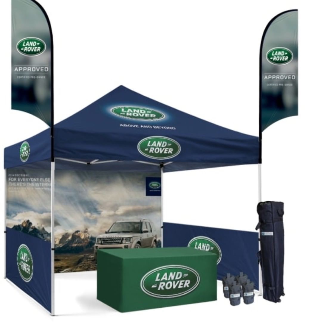 Land Rover branded gazebo set with table covers and flags at an outdoor event