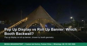 White star-shaped event canopy tent with a central mast and warm lights at dusk